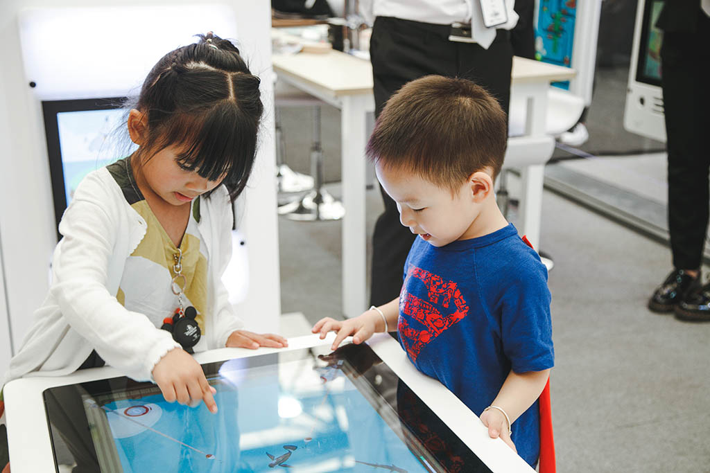 δύο παιδιά παίζουν με τα διαδραστικά συστήματα παιχνιδιών του IKC